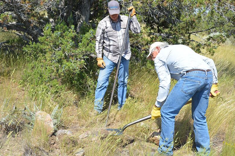A cadastral survey team in the field resurveying a boundary line with modern equipment