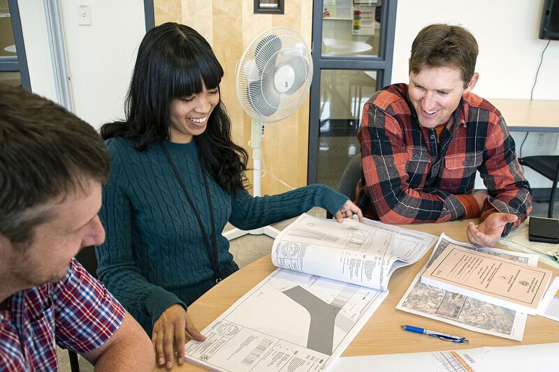 Two engineers reviewing drawings together, comparing details on a project