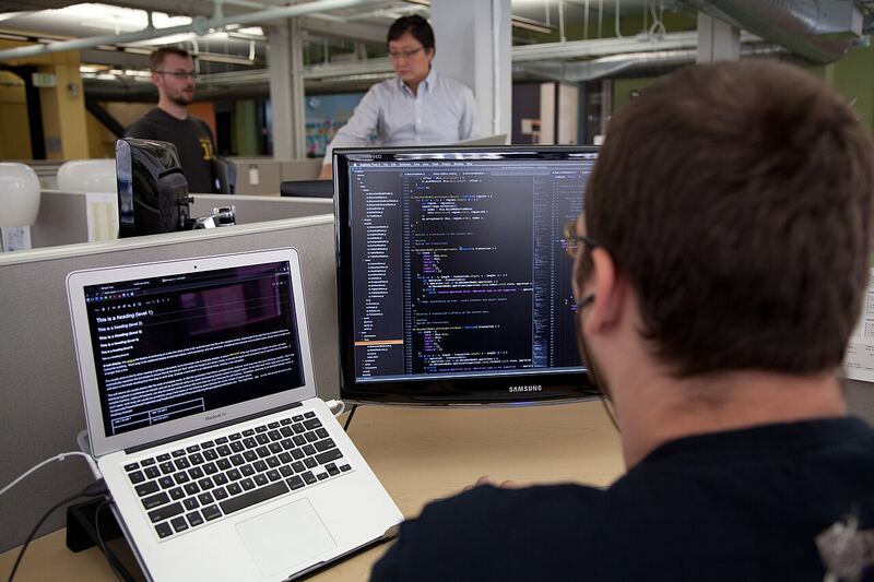 A developer writing and testing code on a laptop, representing Visual LISP script development